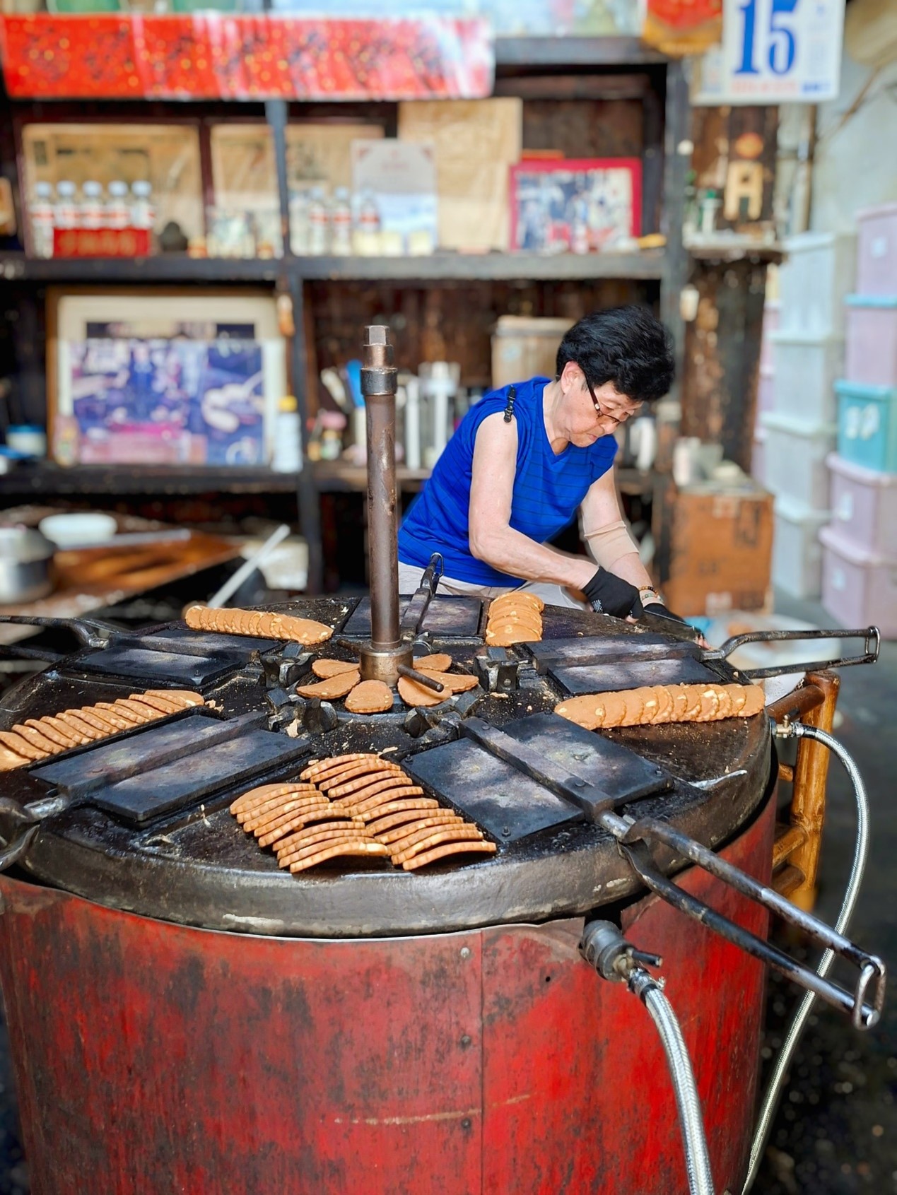 ▲老式煎餅機烤餅的樣子，令不少人佇足觀賞，圖為第三代製餅的情形。（張耘書拍攝）
